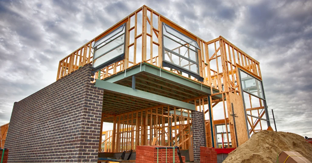 A house under construction with a wooden frame and brick walls